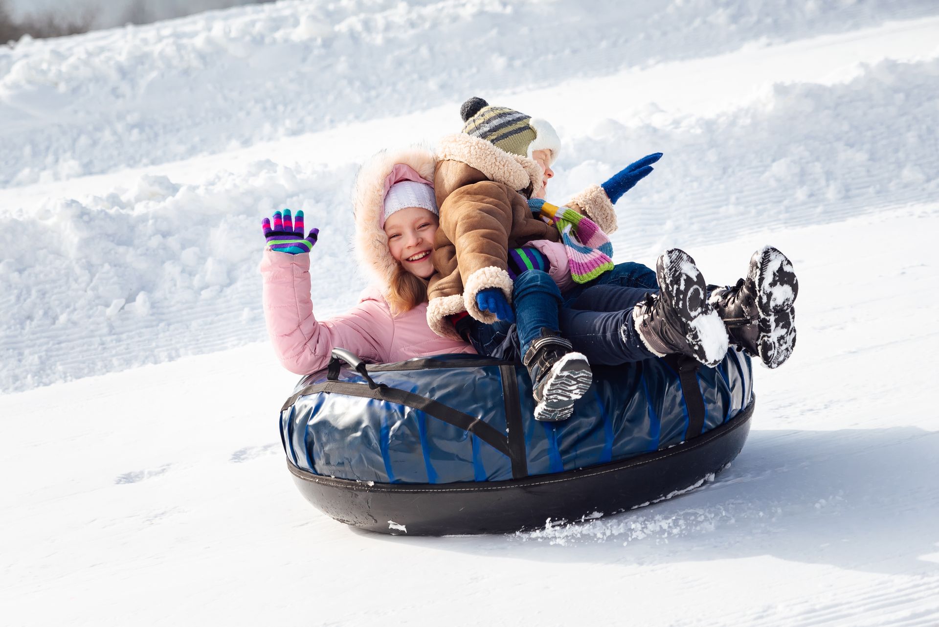 A group of children are riding down a snow tube.