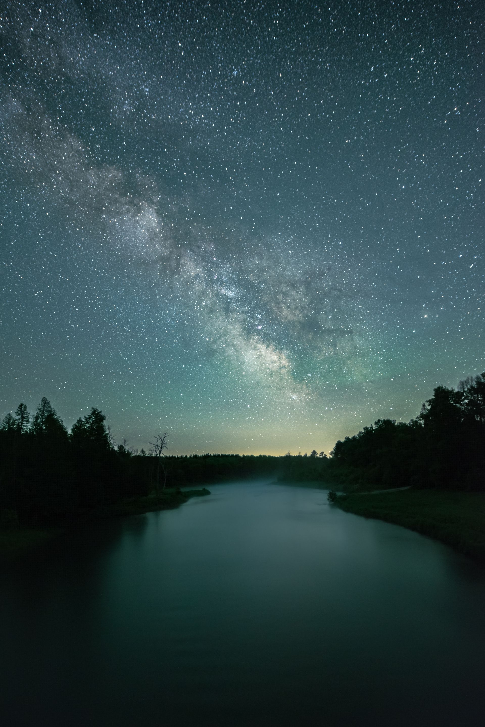 The milky way is visible over a lake at night