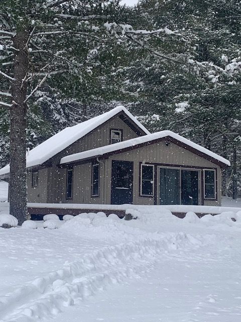 A house covered in snow with trees in the background