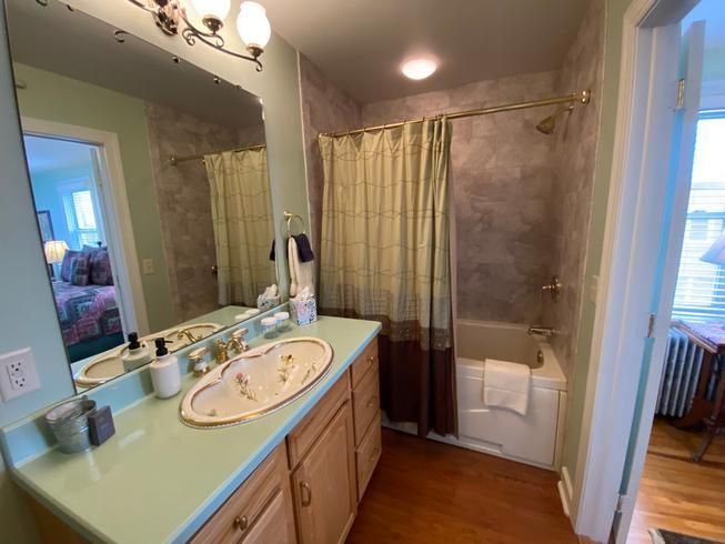 A bathroom with two sinks , a tub and a shower.