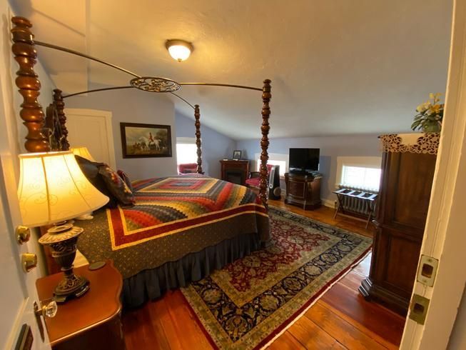 A bedroom with a four poster bed and a rug