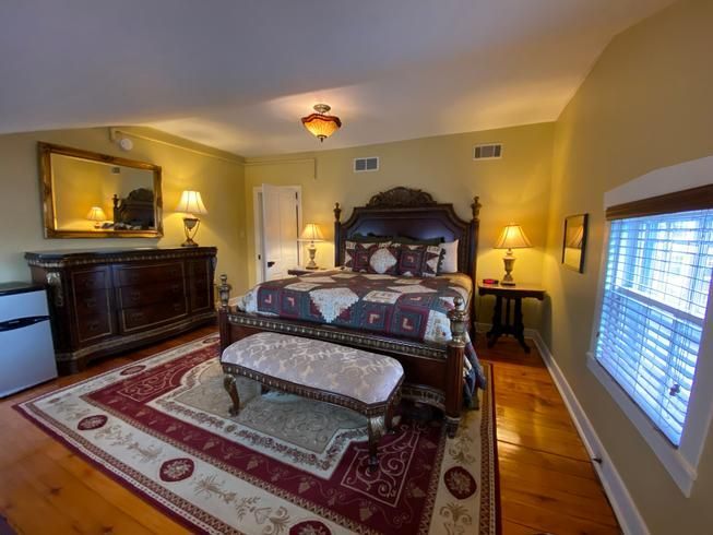 A bedroom with a king size bed and a bench.