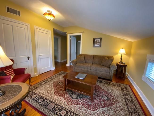 A living room with a couch , chair , coffee table and rug