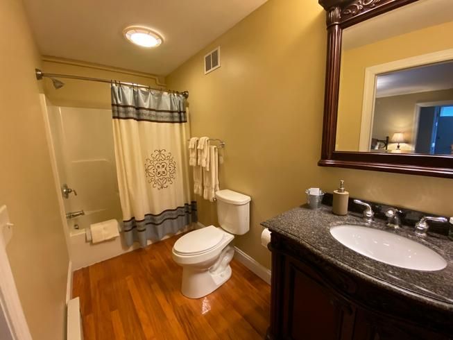 A bathroom with a toilet a sink and a mirror