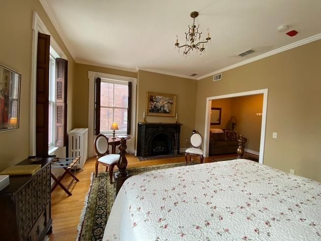 A bedroom with a large bed and a fireplace.