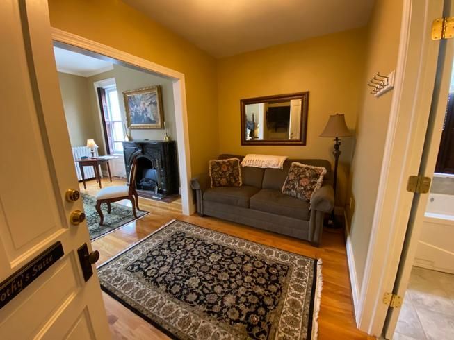 A living room with a couch , rug and fireplace.