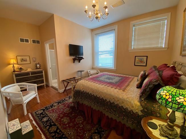 A bedroom with a bed , chair , lamp and television.