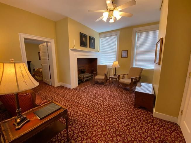 A living room with a fireplace and a ceiling fan