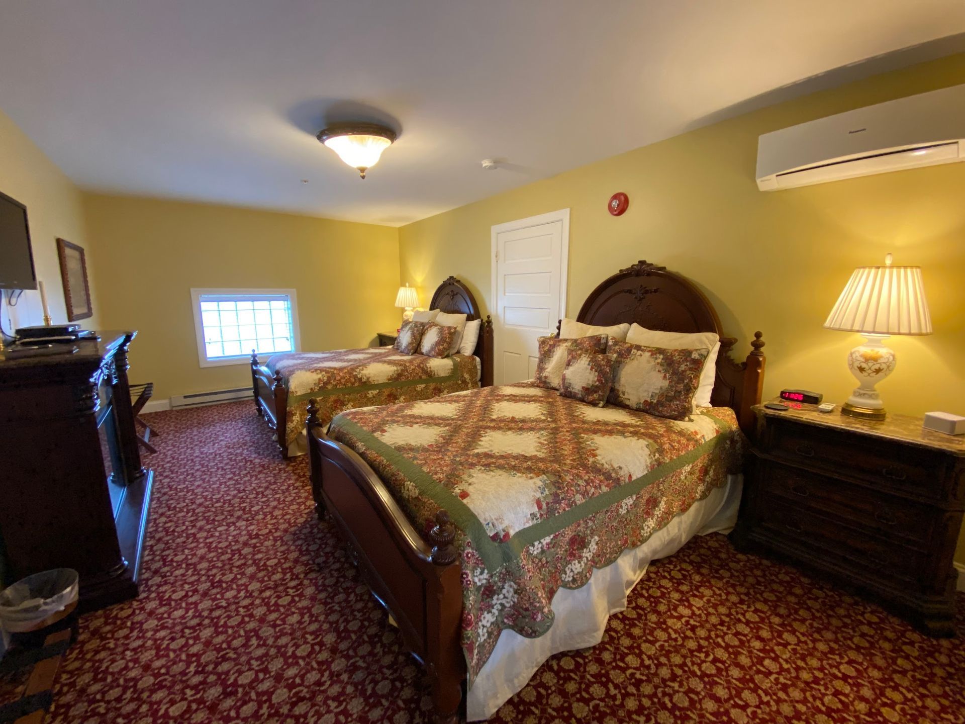 A hotel room with two beds and a dresser