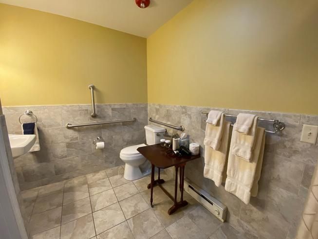 A bathroom with a toilet , sink , and towels.