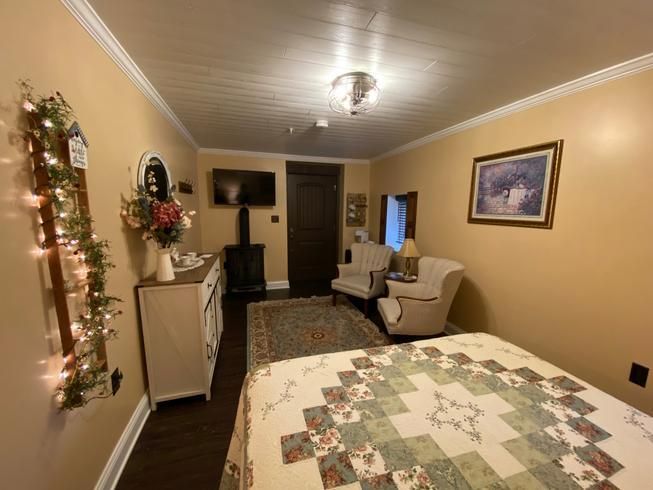 A bedroom with a bed , chair , dresser and television.