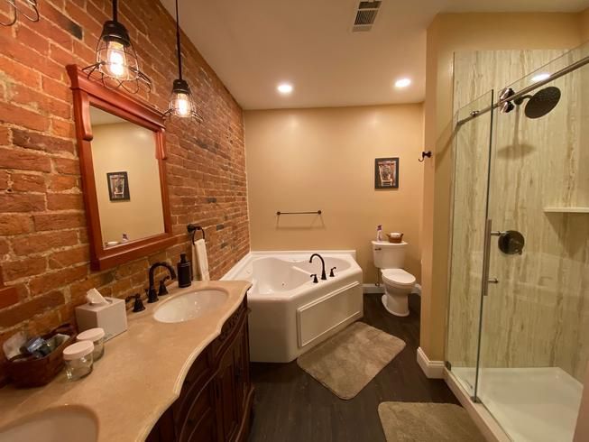 A bathroom with a tub , toilet , sink and shower.