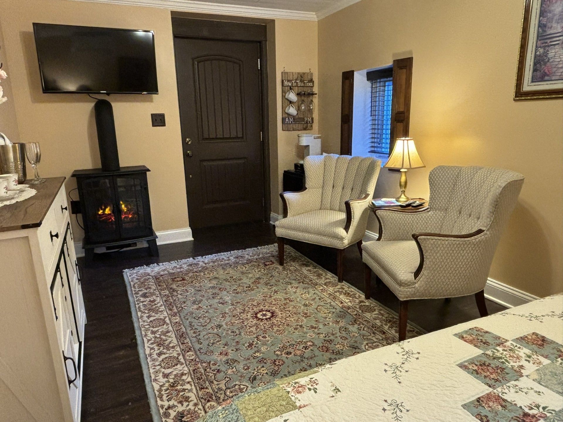 A living room with two chairs , a fireplace and a flat screen tv.