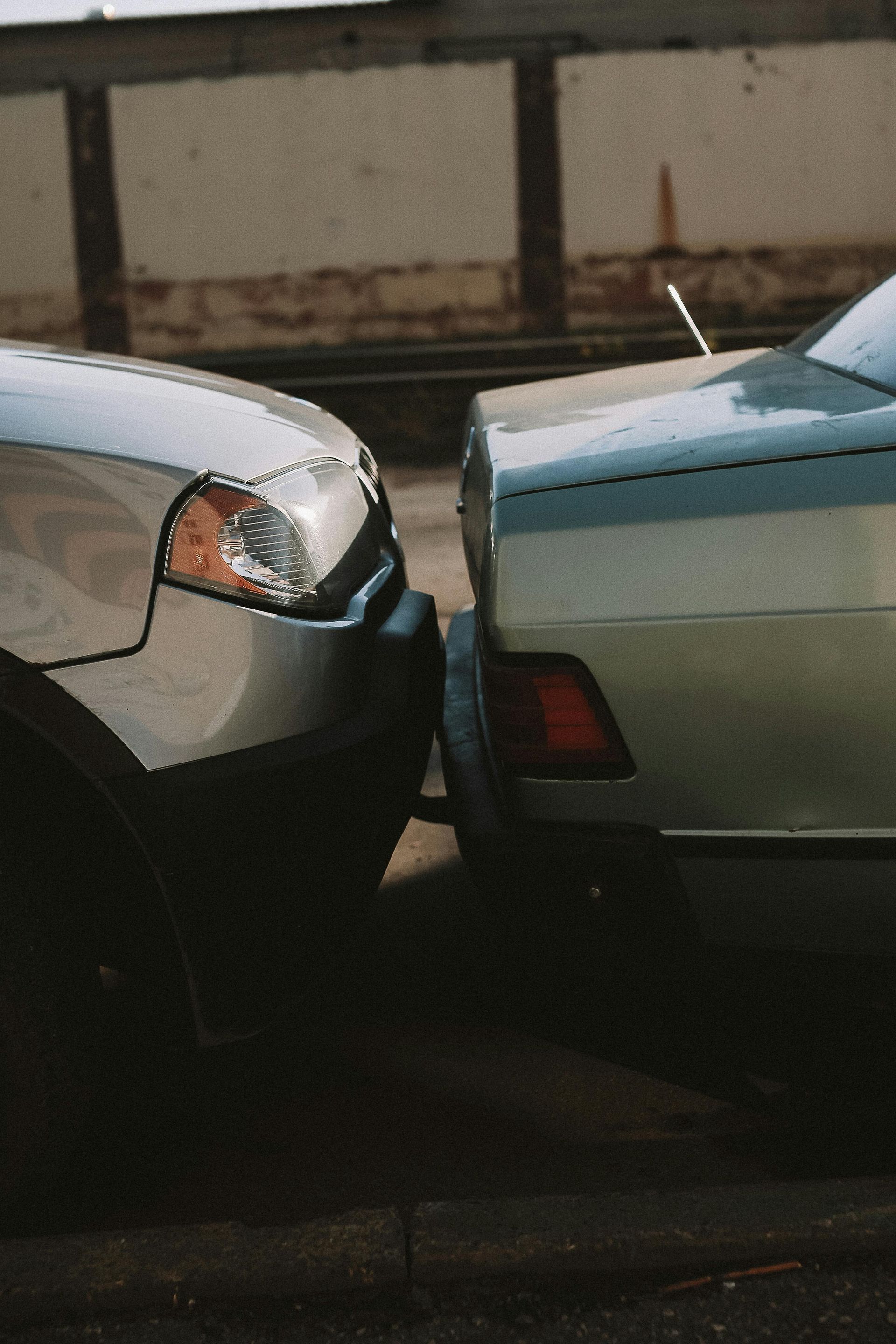 Two cars are parked next to each other on the side of the road