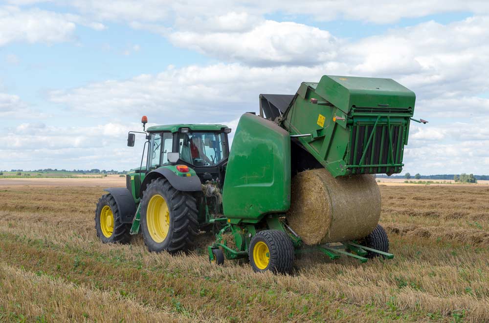 Large Machinery Discharges a Fresh Wheat Bale During Harvesting — Diesel Fitter and Mechanic In Bundaberg East, QLD