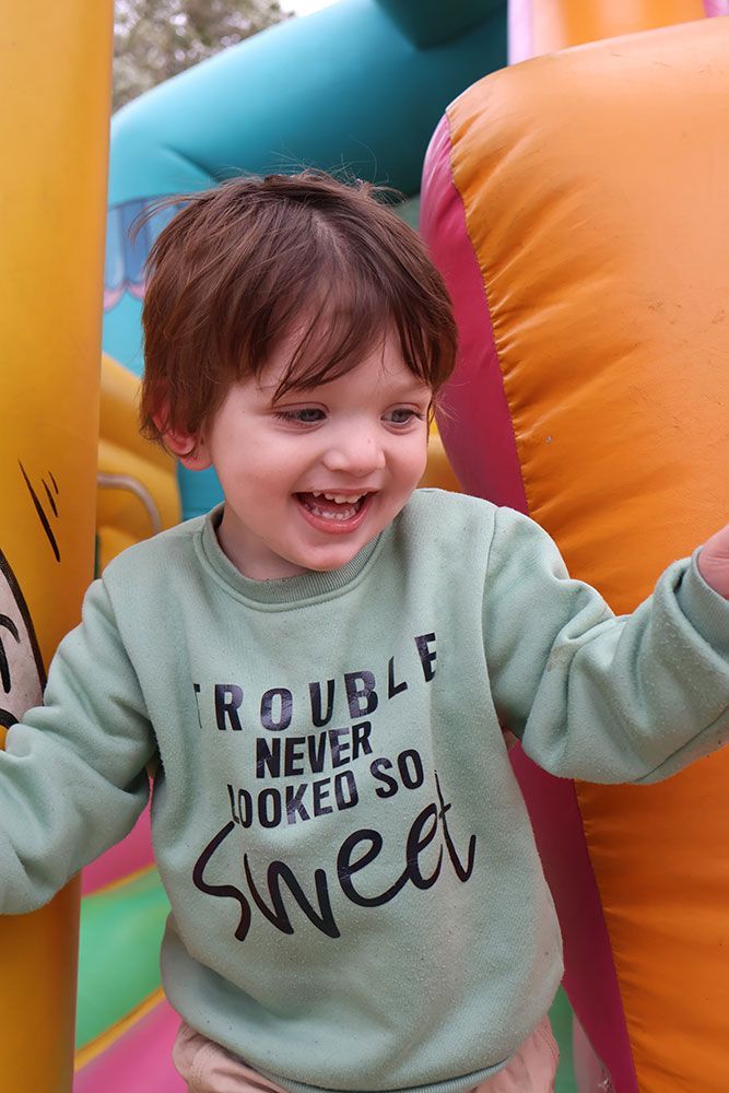 A Little Boy Wearing A Sweater On An Inflatable Bouncy Castle — Bills Amusements In Rockhampton, QLD