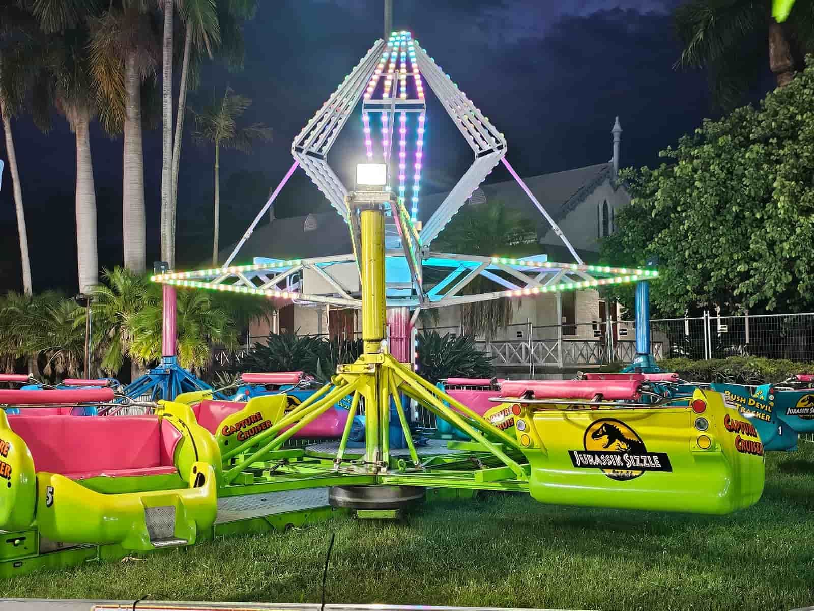 A Carnival Ride Is Sitting In The Grass At Night — Bills Amusements In Rockhampton, QLD