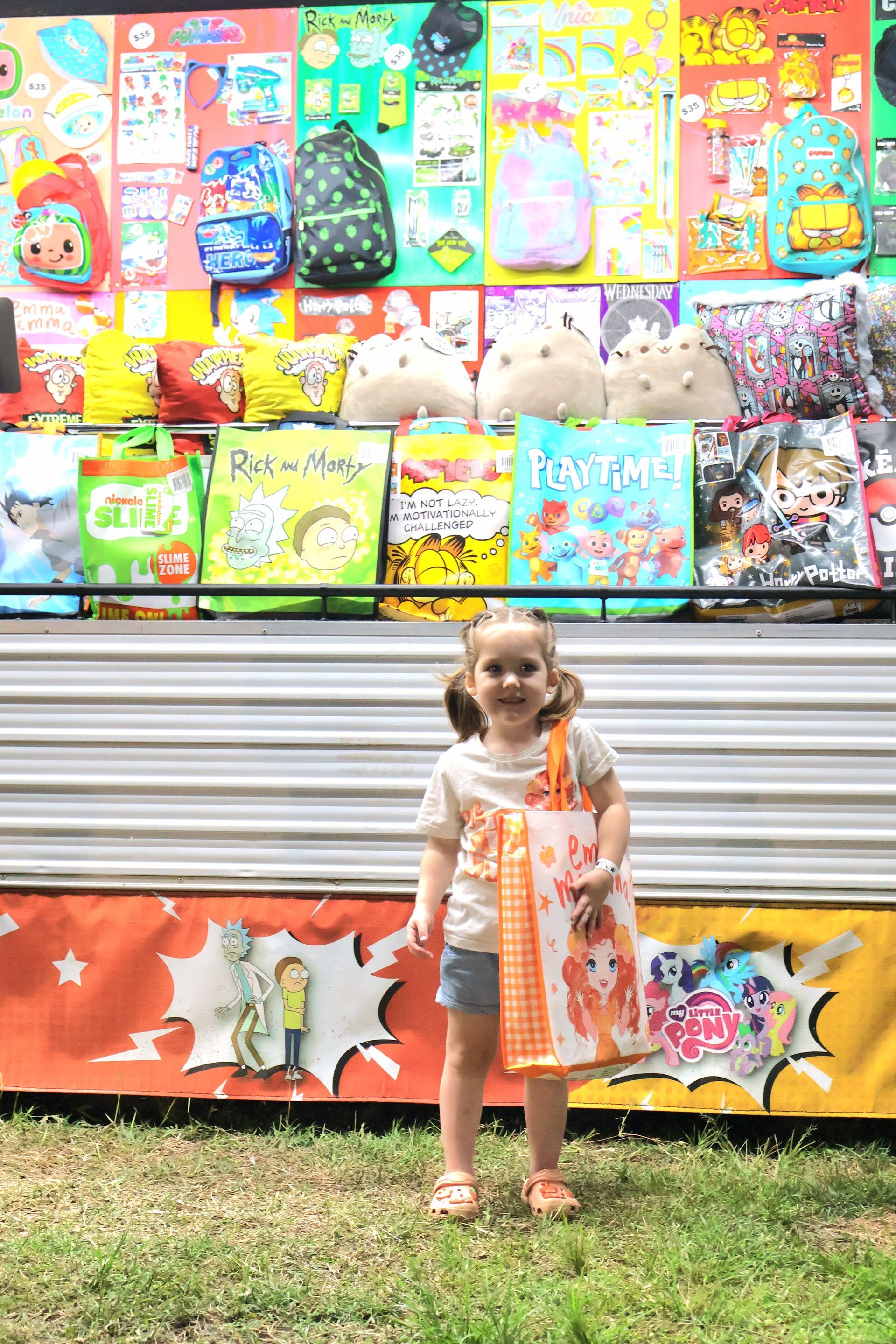 A Young Girl Holding A Bag In Front Of A Showbag Stand — Bills Amusements In Rockhampton, QLD