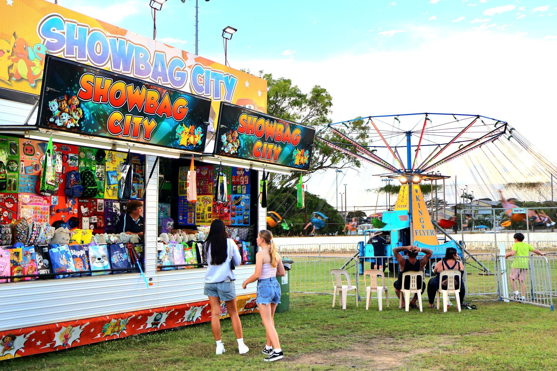 Two Girls Are Standing In Front Of A Carnival Booth — Bills Amusements In Rockhampton, QLD
