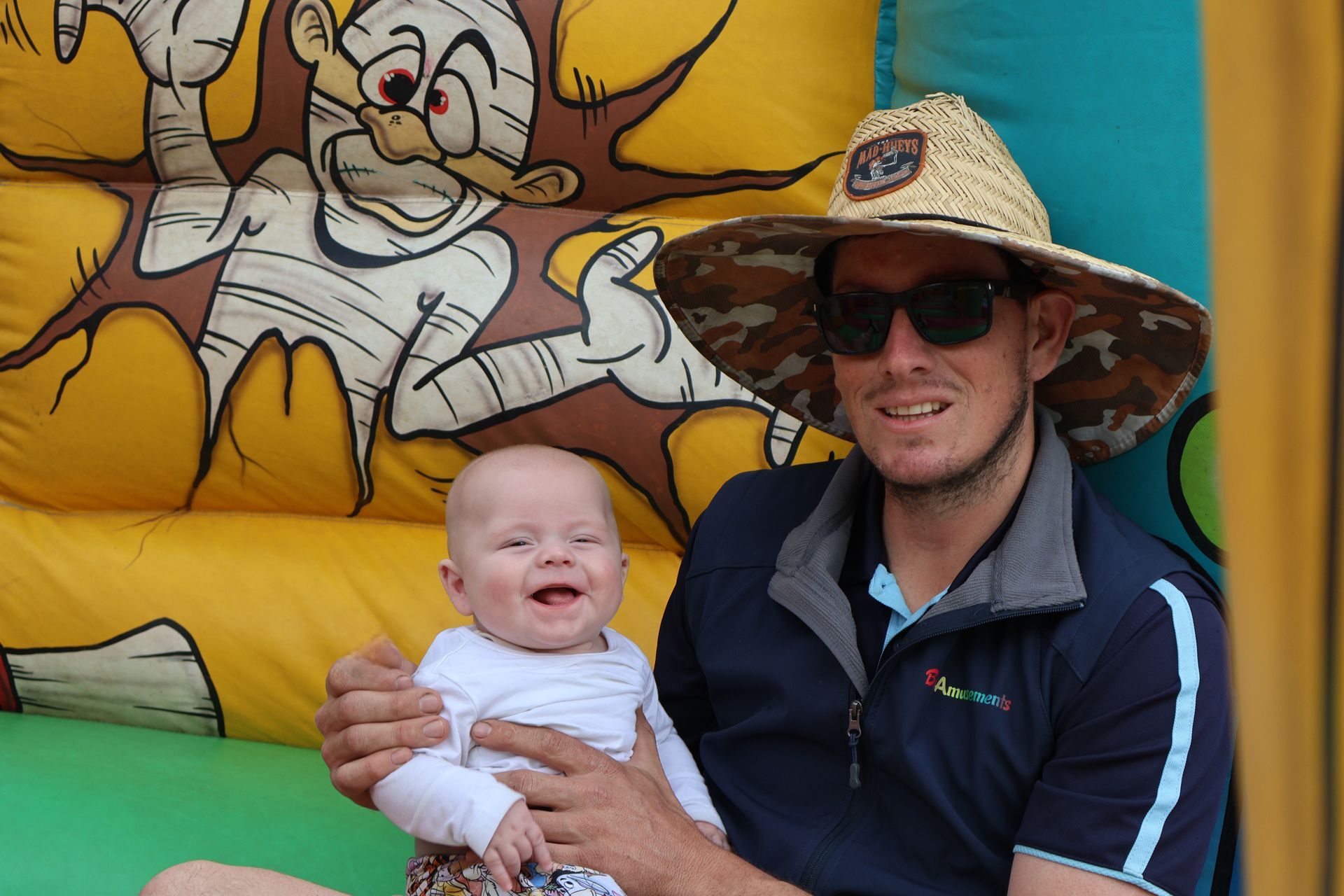 A Man Holding A Baby — Bills Amusements In Rockhampton, QLD