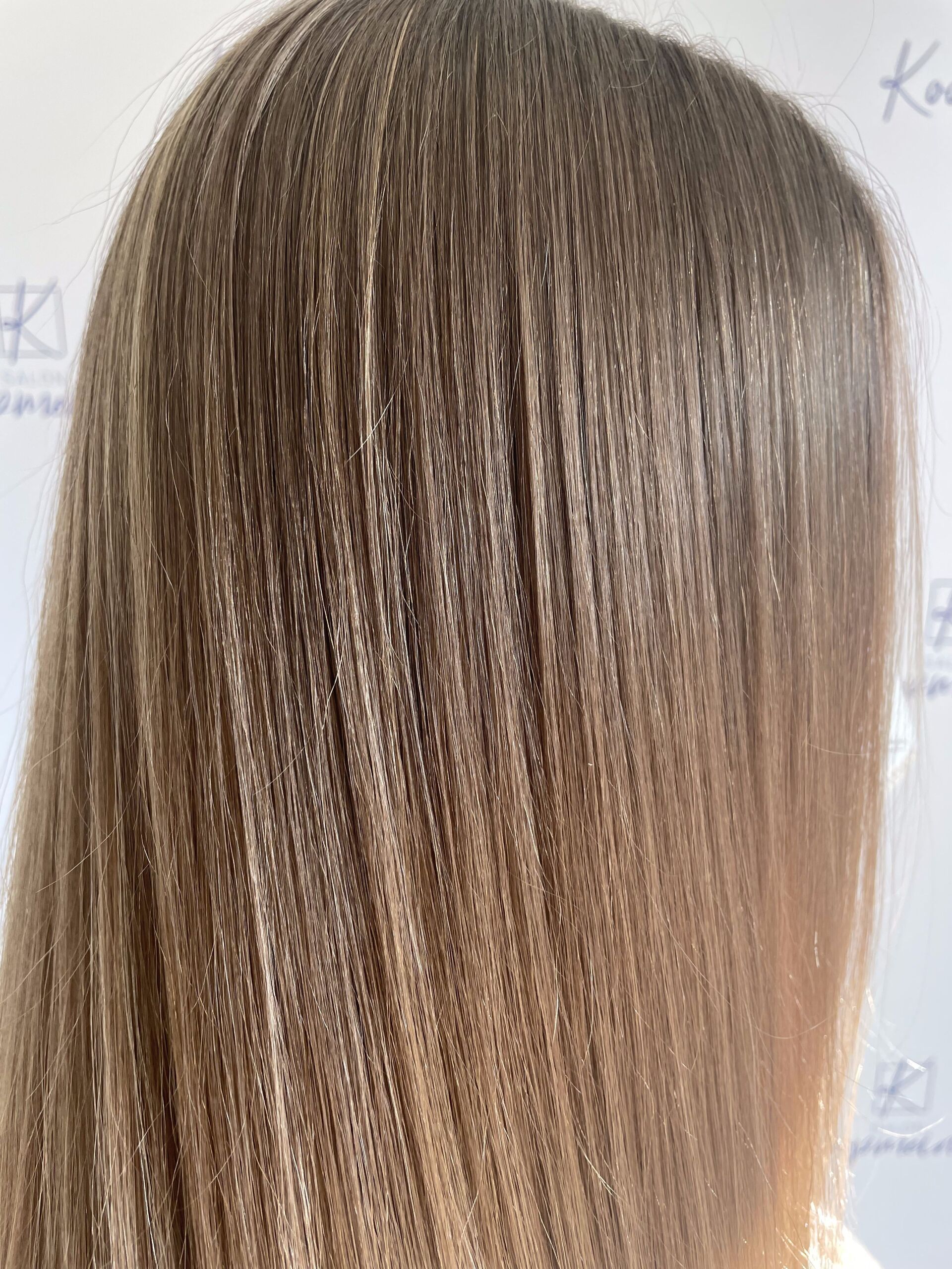 Nahaufnahme von mit einem Crimper gestyltem Haar, wodurch ein strukturierter, welliger Effekt in Brauntönen entsteht.