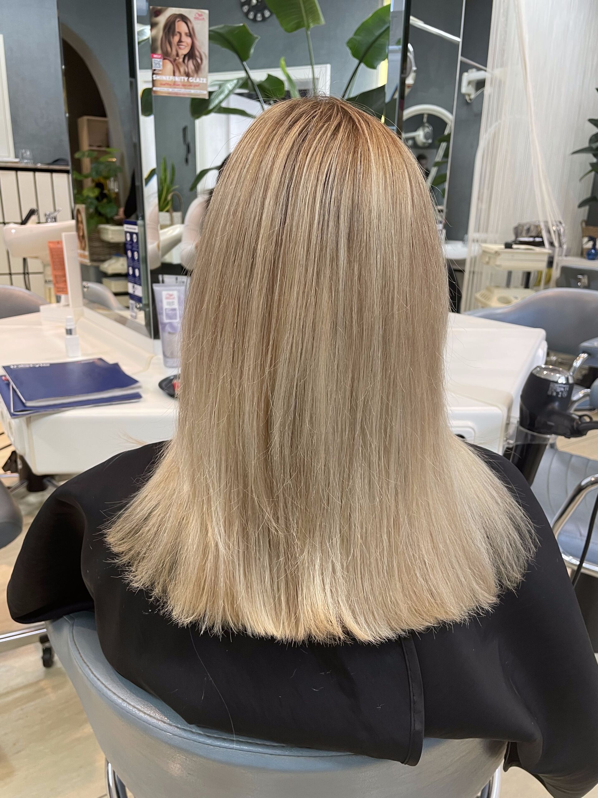 Frau mit blondem, gekräuseltem Haar in einem Salon.