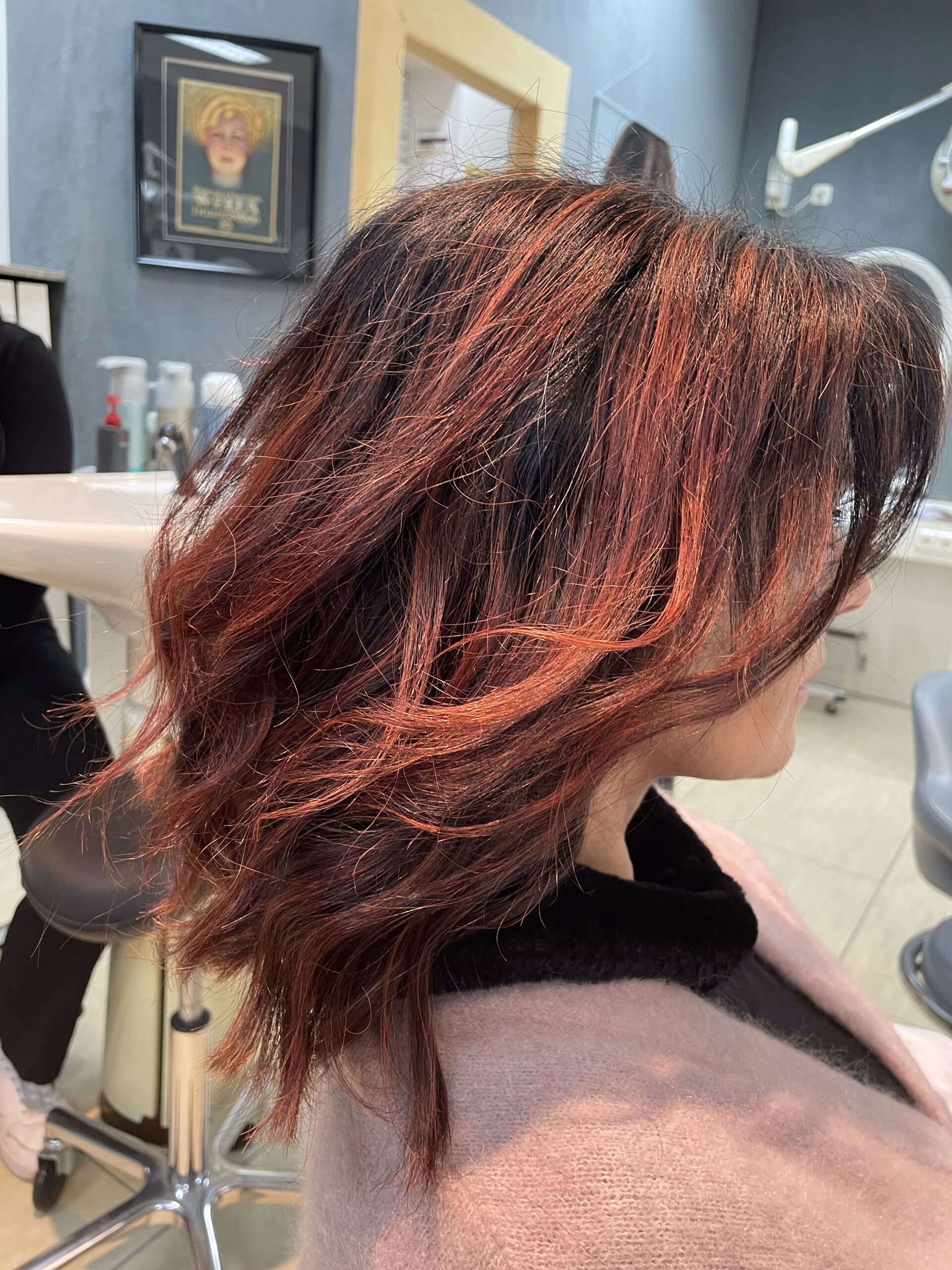 Frau mit kastanienbraunem und dunklem Haar in einem Salon.