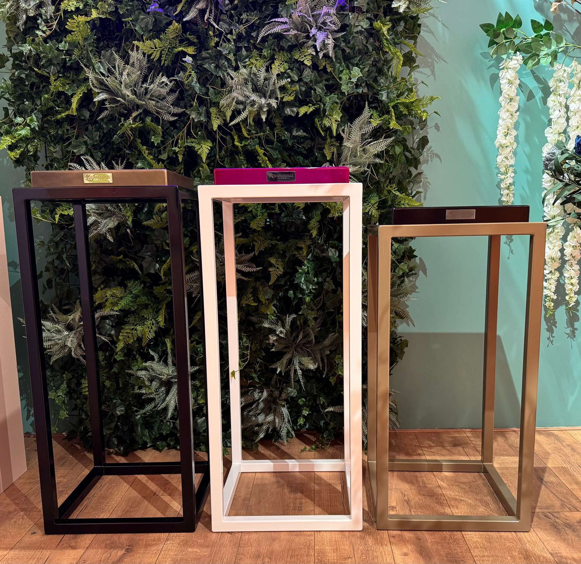 Drie tafels staan opgesteld voor een groene muur