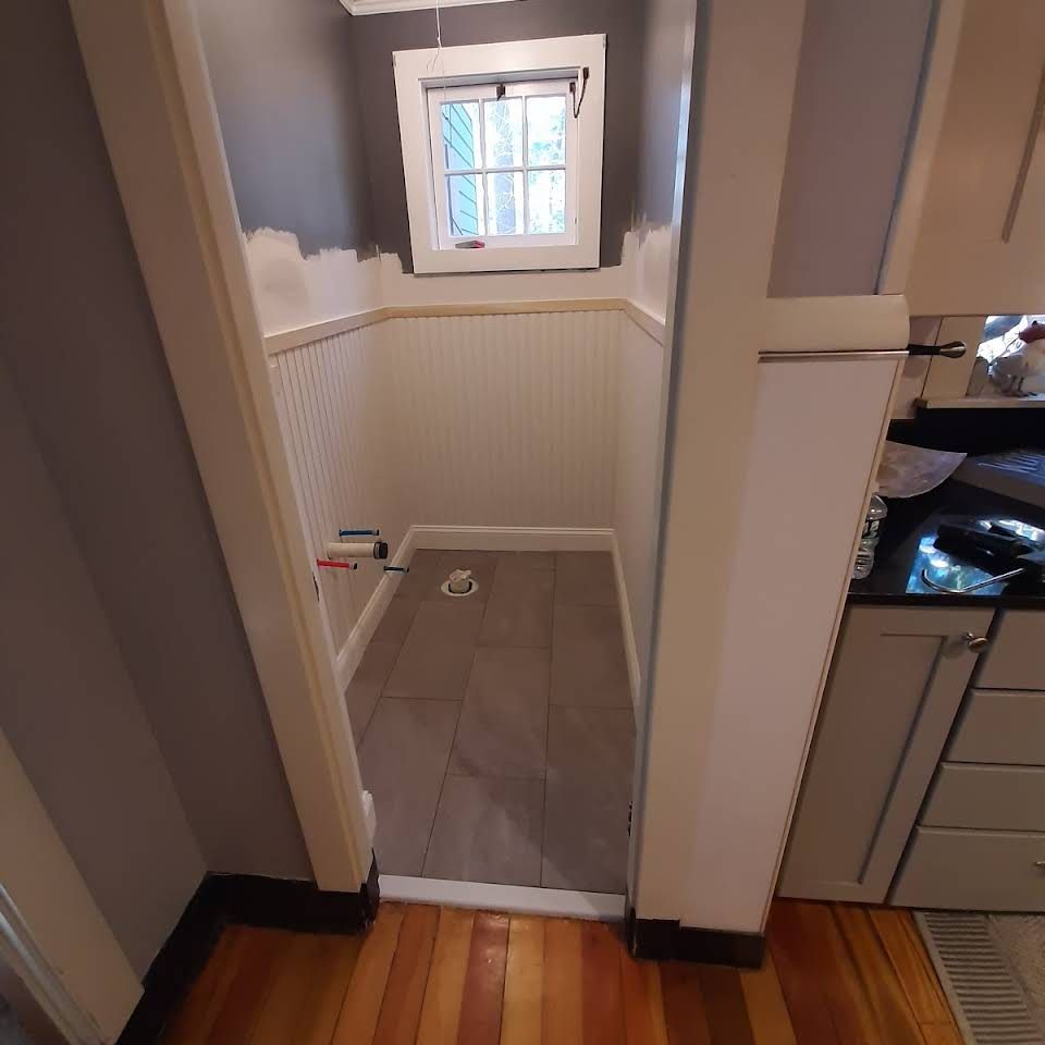 A bathroom with hardwood floors and a window.