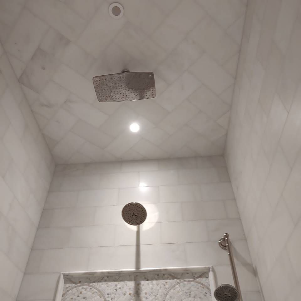 A shower with a shower head hanging from the ceiling.