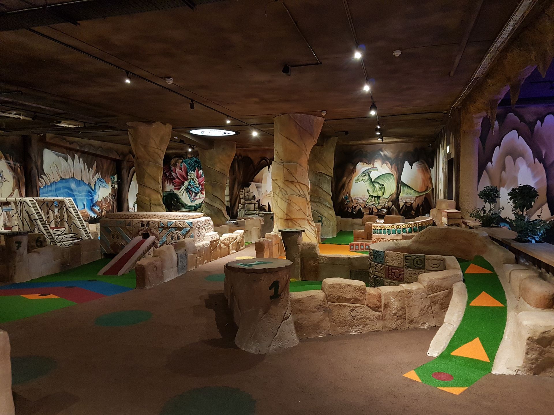 A large room with a lot of furniture and paintings on the walls.