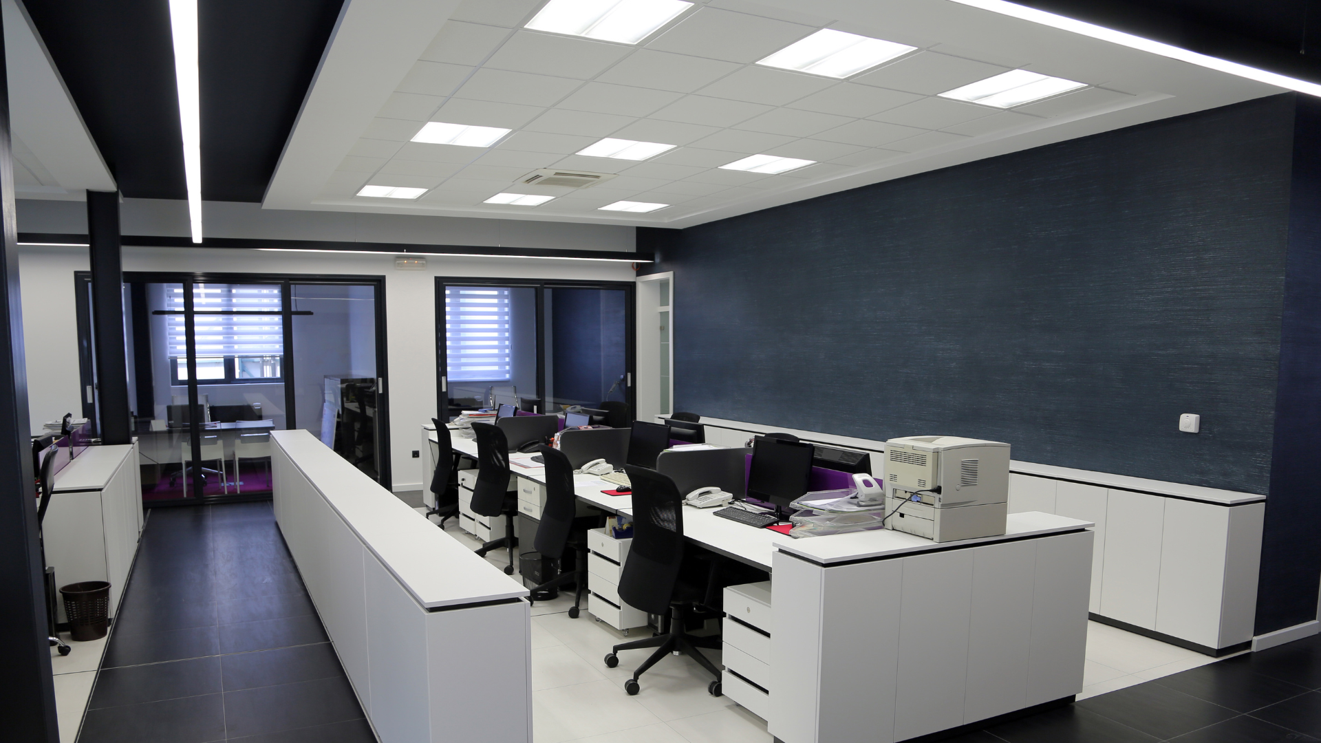 A large office with a lot of desks and chairs.