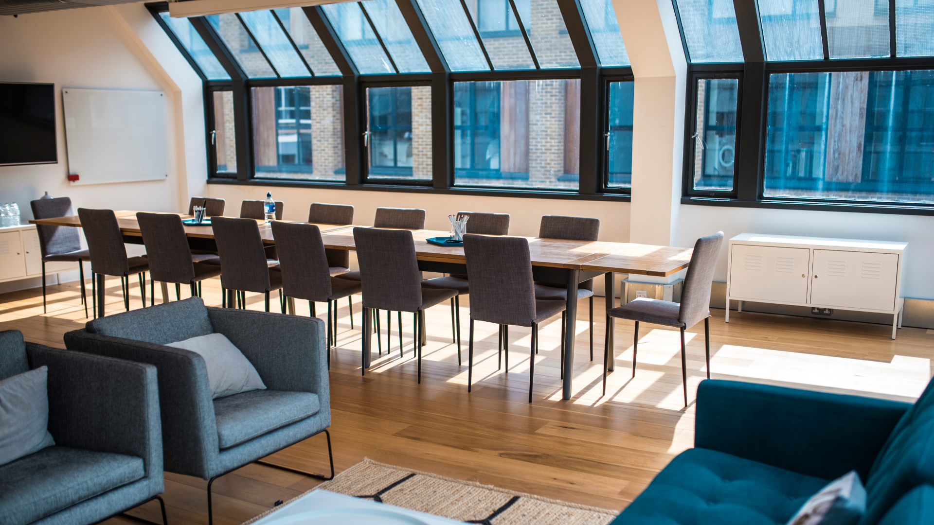 A living room with a couch , chairs , tables and windows.
