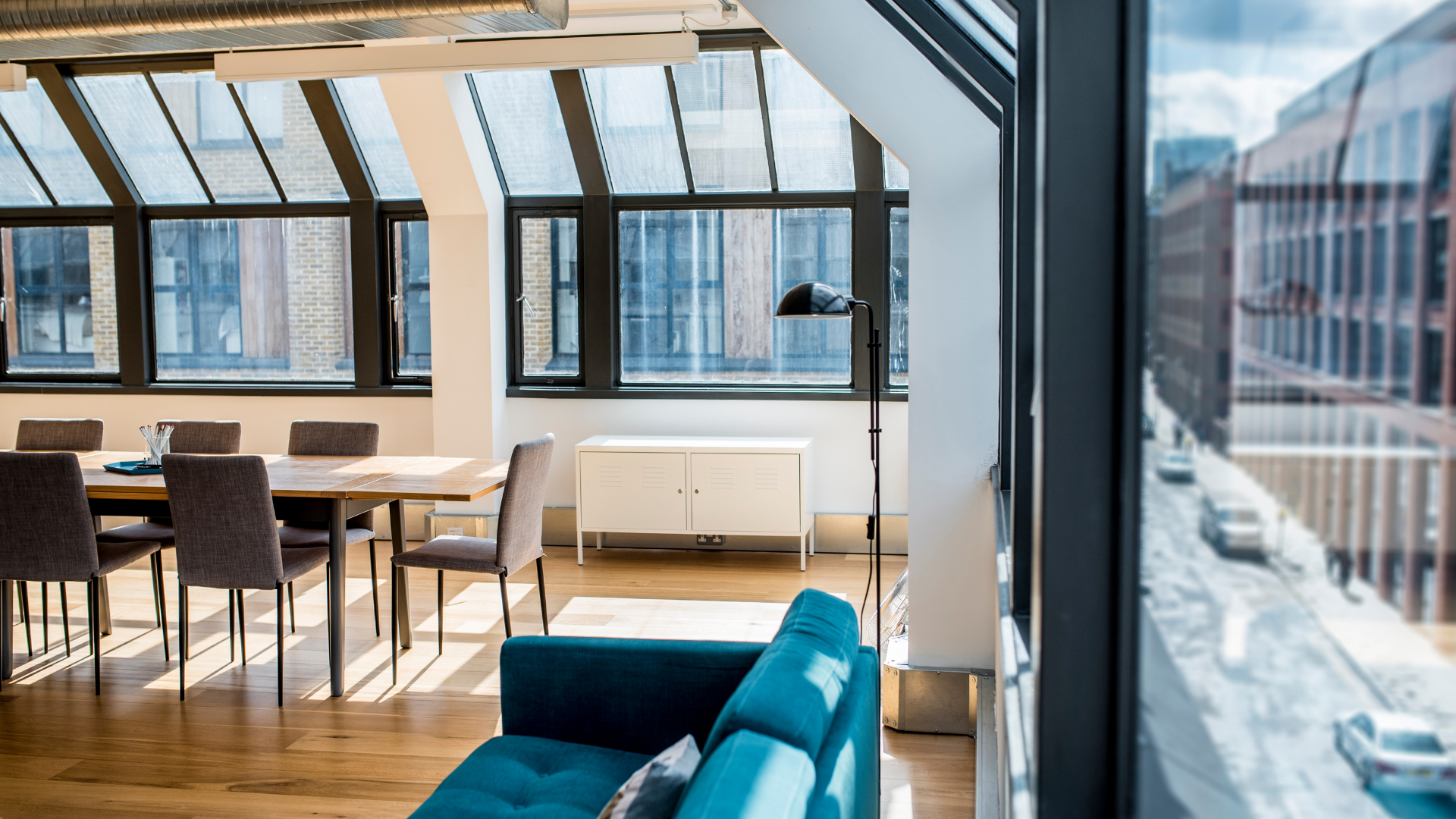 A living room with a blue couch and a table and chairs.