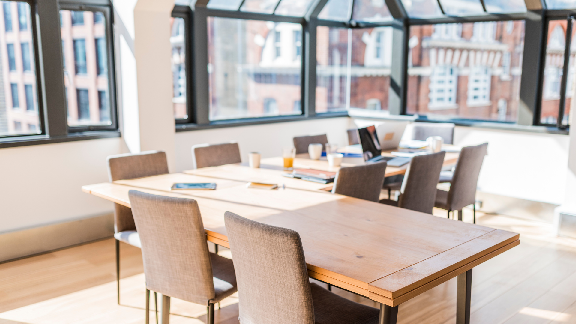 A conference room with a long wooden table and chairs.