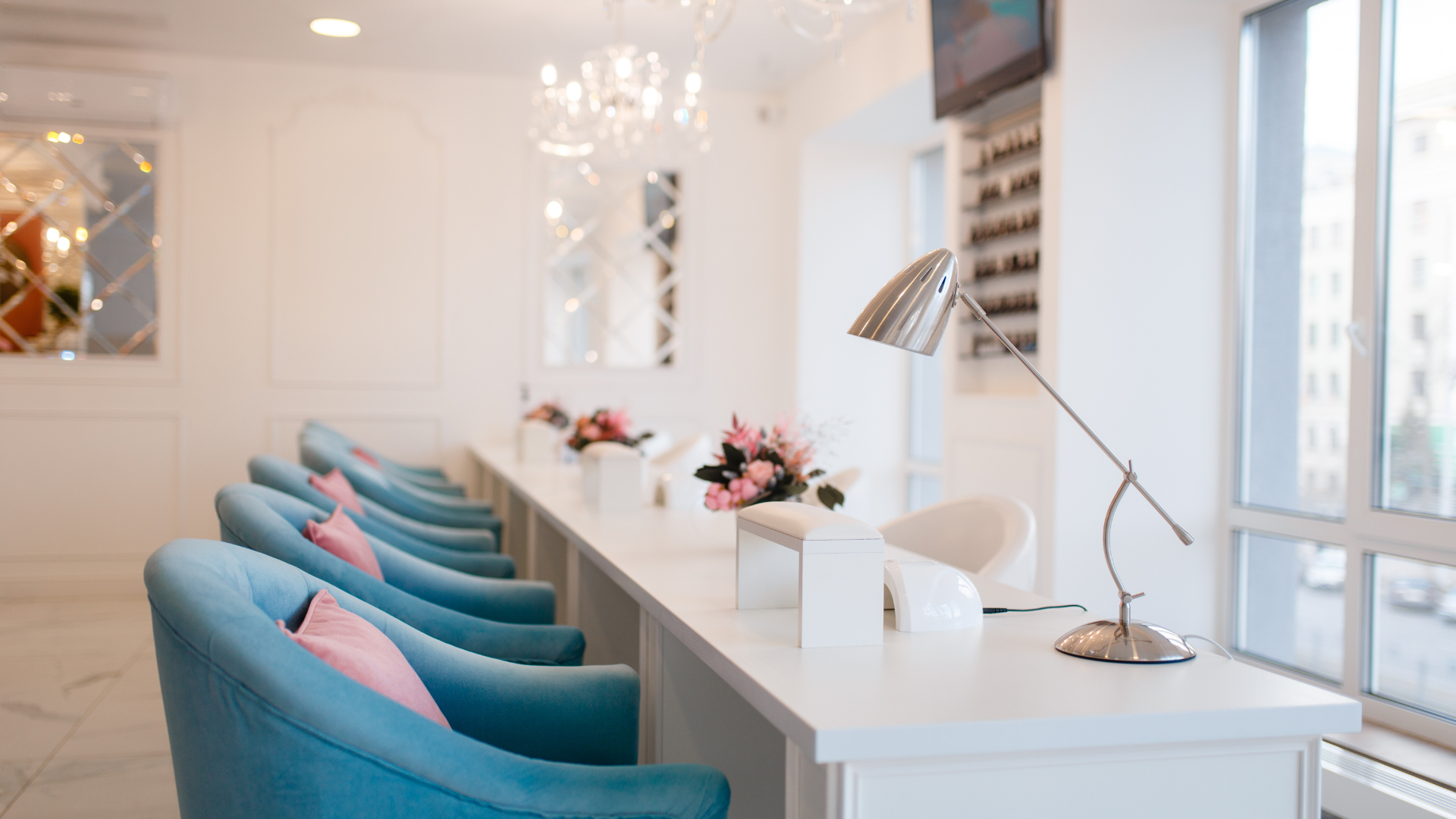 A row of blue chairs sitting next to each other in a nail salon.