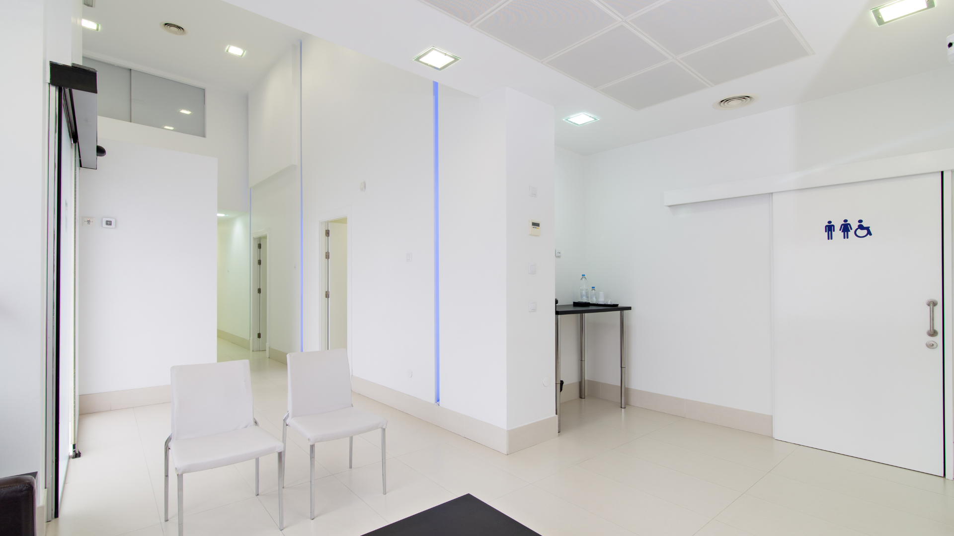 A waiting room with chairs and a sign that says ' sliding doors ' on it