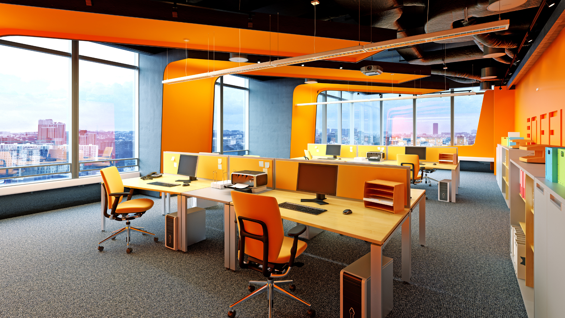 An office with orange walls and a lot of windows
