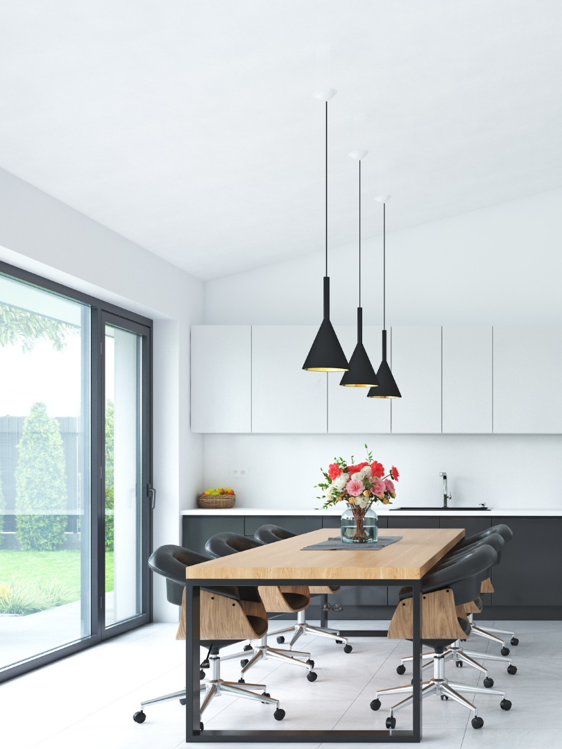 A kitchen with a table and chairs and a vase of flowers on the table.