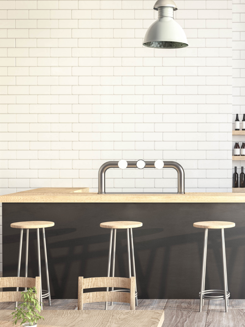 A kitchen with a bar , stools and a table.