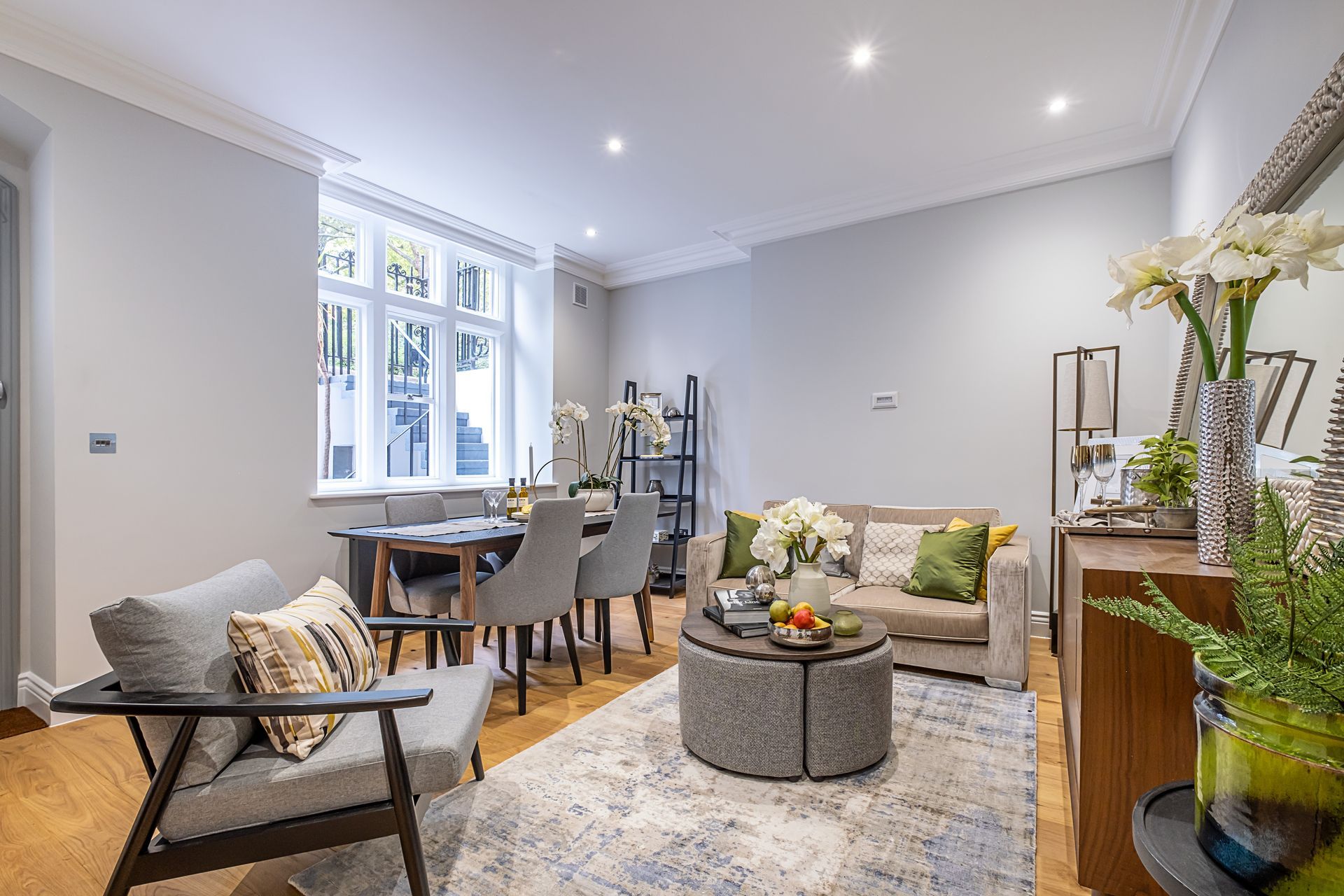 A living room with a couch , chairs , a table and a rug.