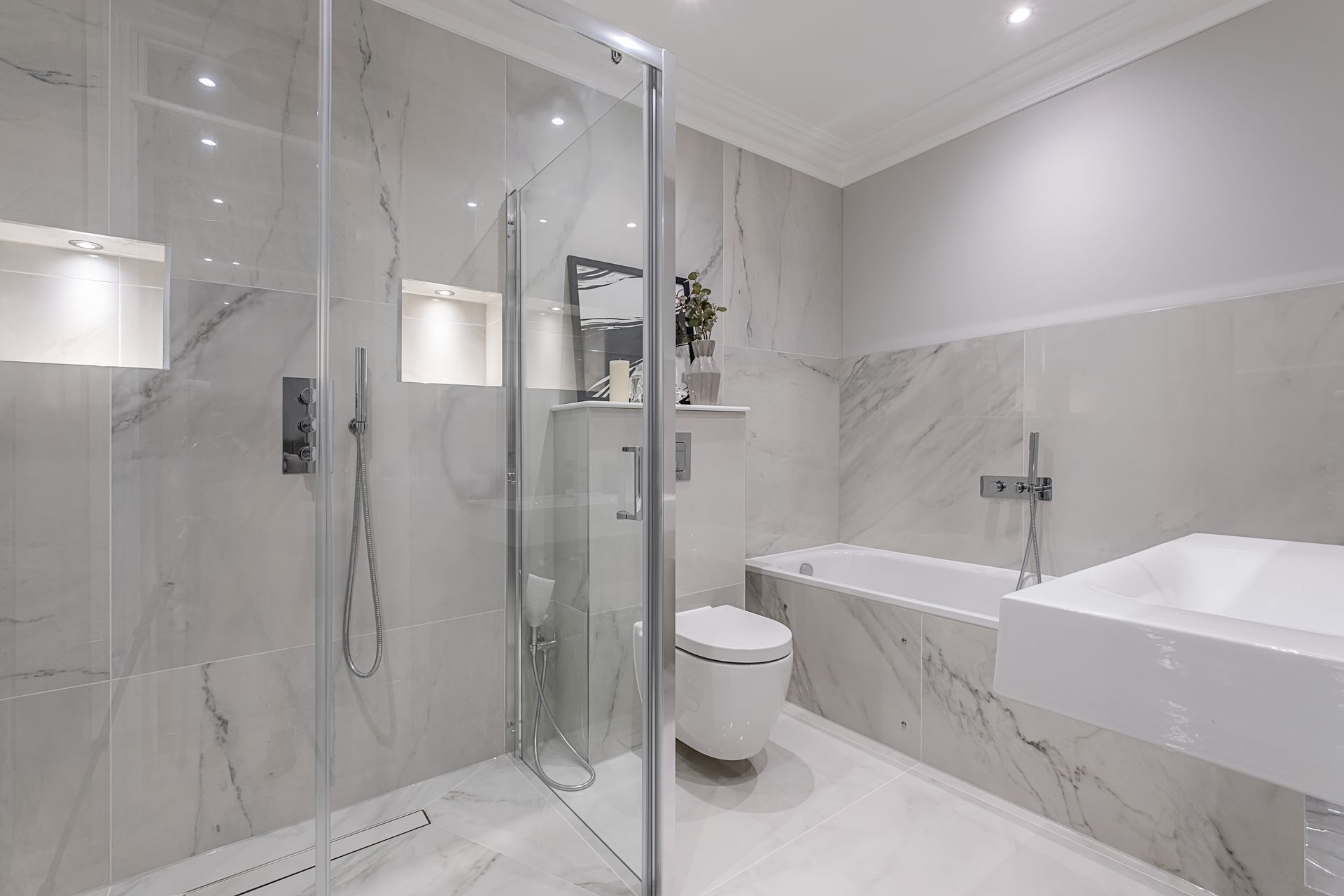 A bathroom with a walk in shower , toilet , sink and bathtub.