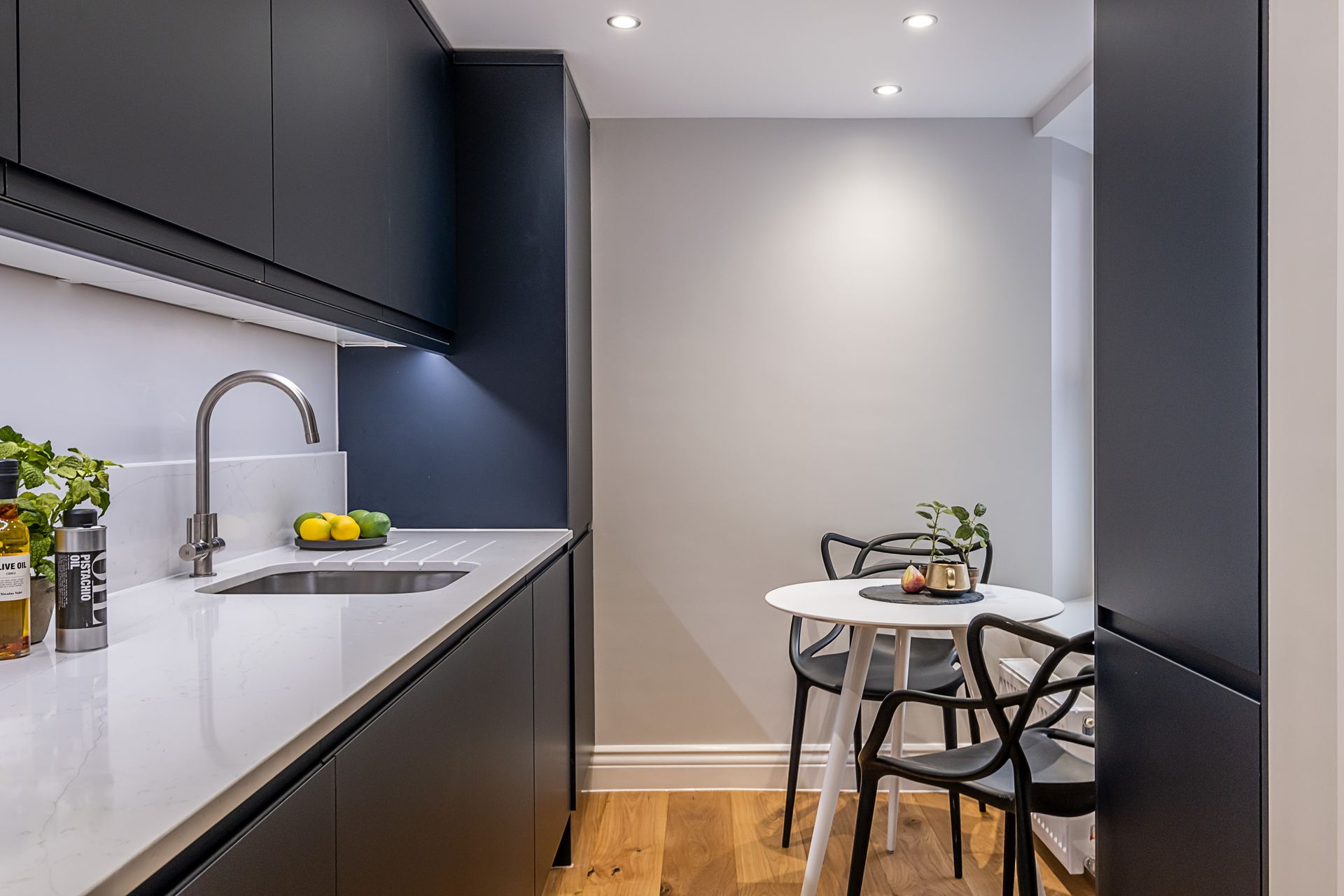 A kitchen with a table and chairs and a sink.