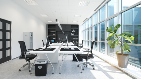 An office with a lot of windows and tables and chairs.