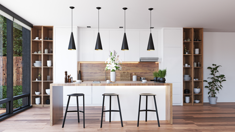 A modern kitchen with white cabinets , wooden counter tops , stools and a large island.