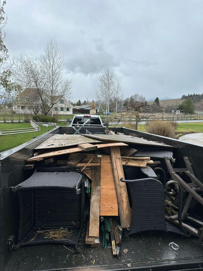 A pile of wood is sitting on the back of a truck.
