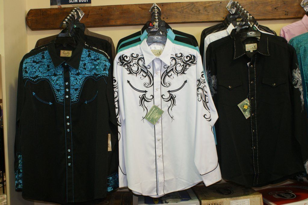 A selection of western shirts hangs on a rack.