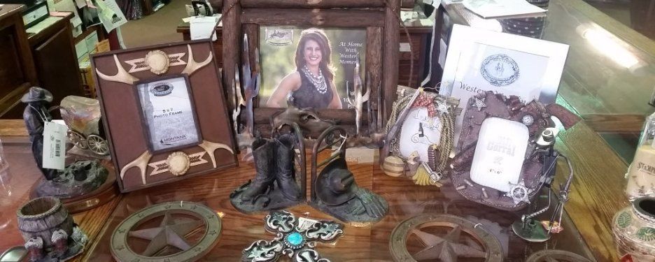 Display of Western-themed items: picture frames, boots, and a framed photo.