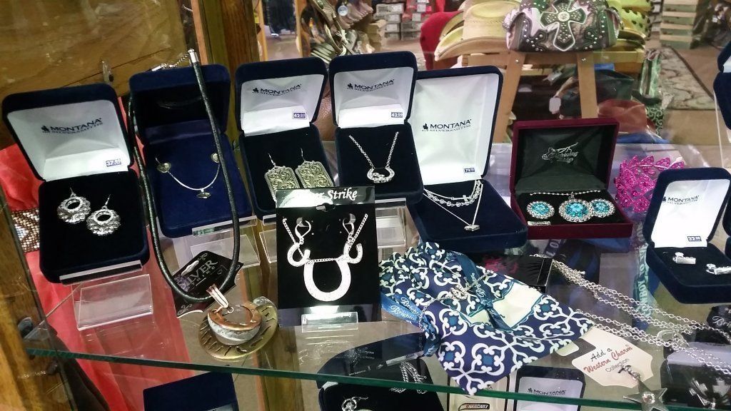 A glass display case containing a variety of necklaces and bracelets.