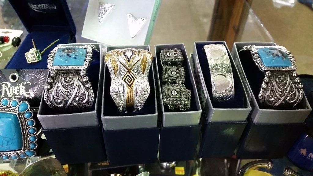 Display case with various ornate silver bracelets, some with turquoise accents, in individual boxes.